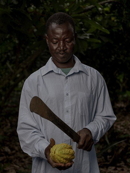 A cocoa farmer holding a pod