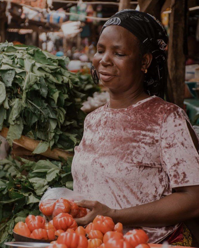 African trader displaying her tomatoes at the market