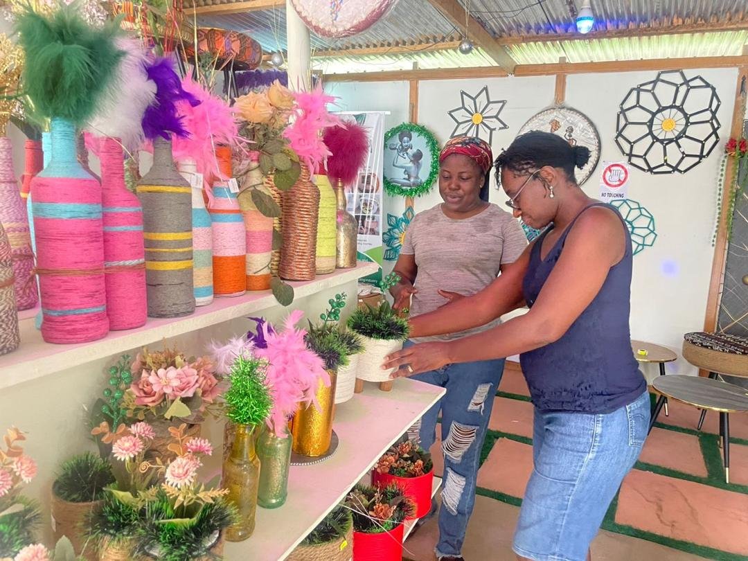 Charlotte a producer of recycled interior decor items displays her products to Mrs. Amma Adjeiwaa Antwi, founder of BAWYP.